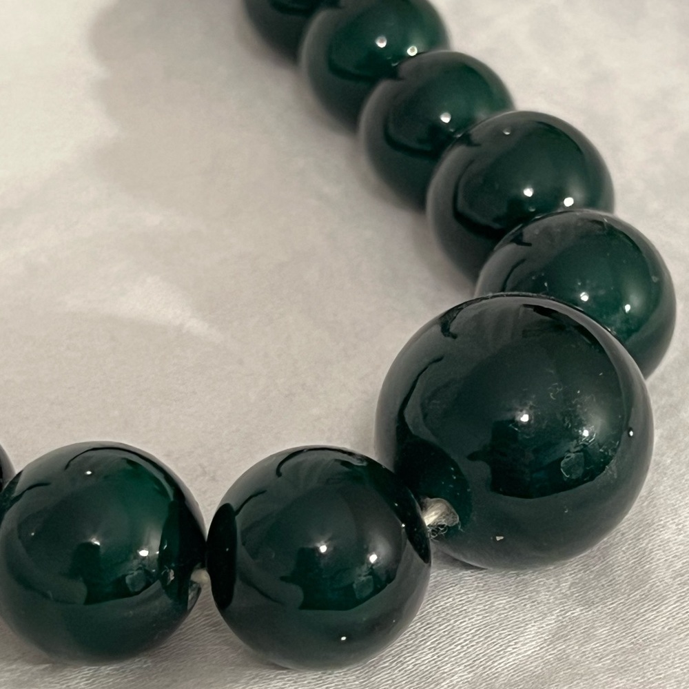 Long dark green beaded necklace.